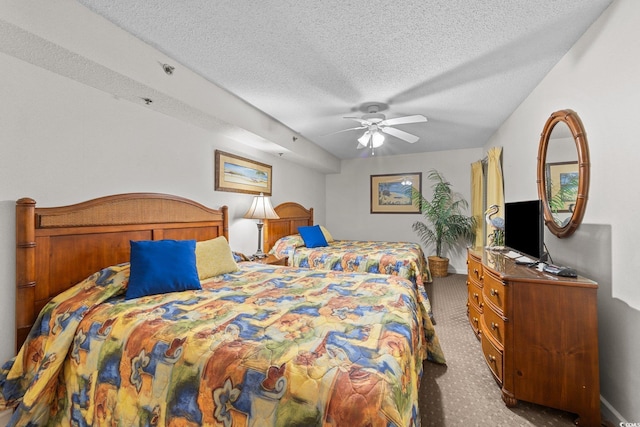 bedroom featuring ceiling fan, carpet floors, and a textured ceiling