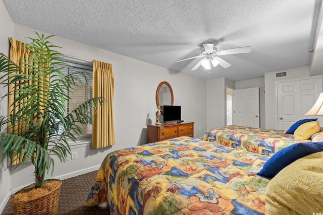 bedroom featuring ceiling fan, carpet floors, and a textured ceiling