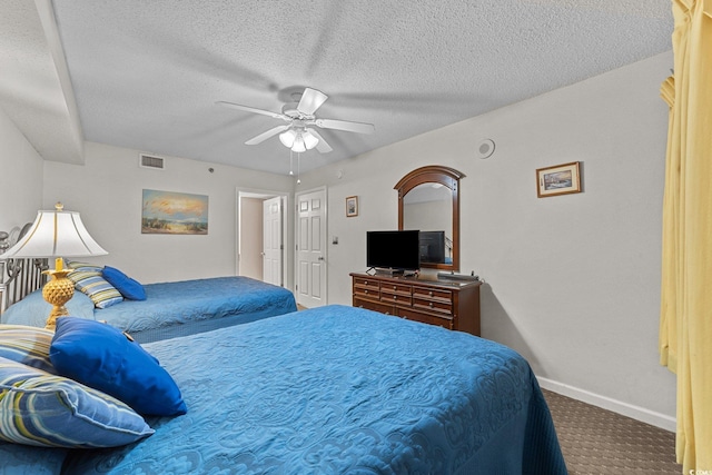 bedroom with ceiling fan, carpet floors, and a textured ceiling