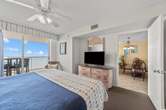 tiled bedroom with a textured ceiling, ceiling fan with notable chandelier, and access to outside