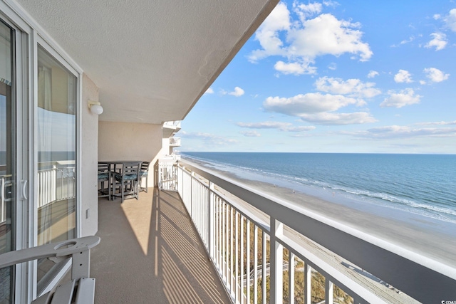 balcony featuring a water view and a view of the beach