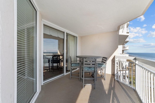 balcony featuring a beach view and a water view