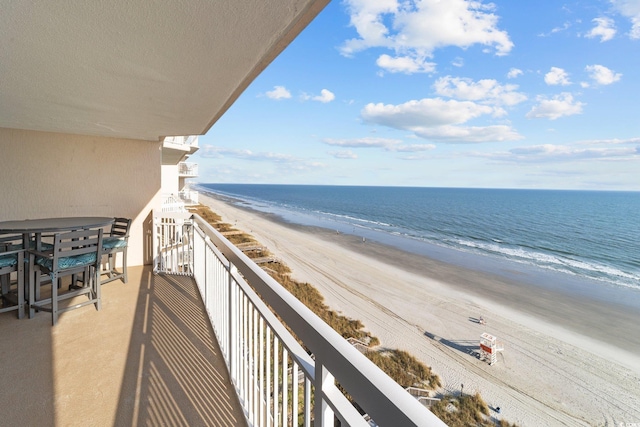 balcony featuring a water view and a view of the beach