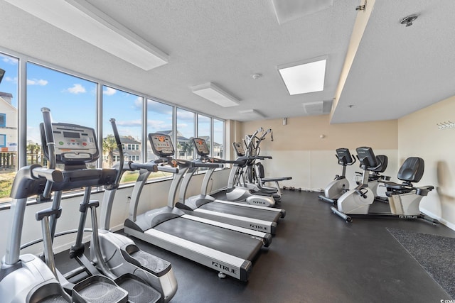 gym with expansive windows and a textured ceiling