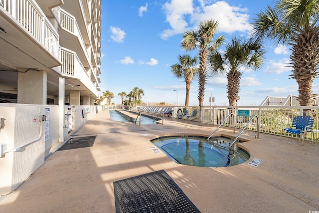 view of swimming pool featuring a hot tub