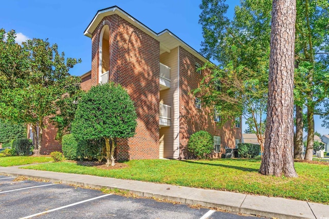 view of home's exterior with a lawn and a balcony