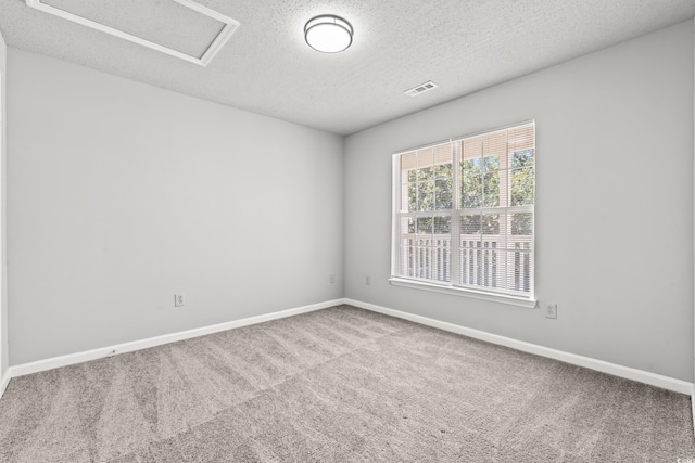 unfurnished room featuring carpet and a textured ceiling