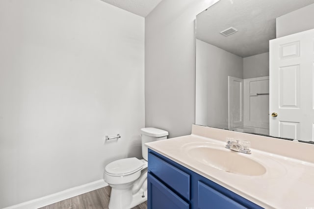 bathroom with vanity, toilet, hardwood / wood-style flooring, and a textured ceiling