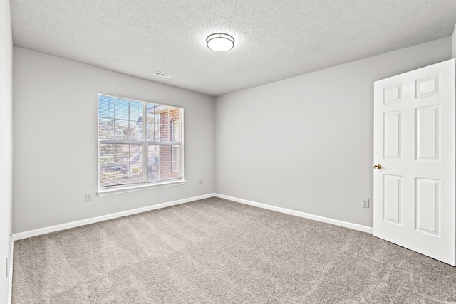 unfurnished room with carpet and a textured ceiling