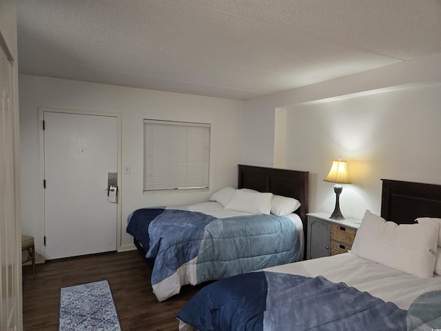 bedroom featuring a textured ceiling and dark hardwood / wood-style floors