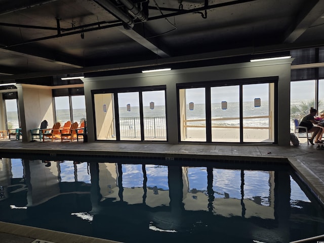 view of swimming pool with a water view and a hot tub