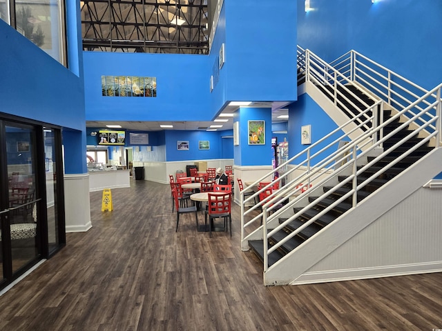 stairway with hardwood / wood-style floors and a high ceiling