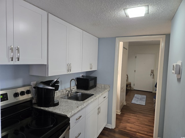 kitchen featuring stainless steel electric stove, white cabinetry, a textured ceiling, and dark hardwood / wood-style floors