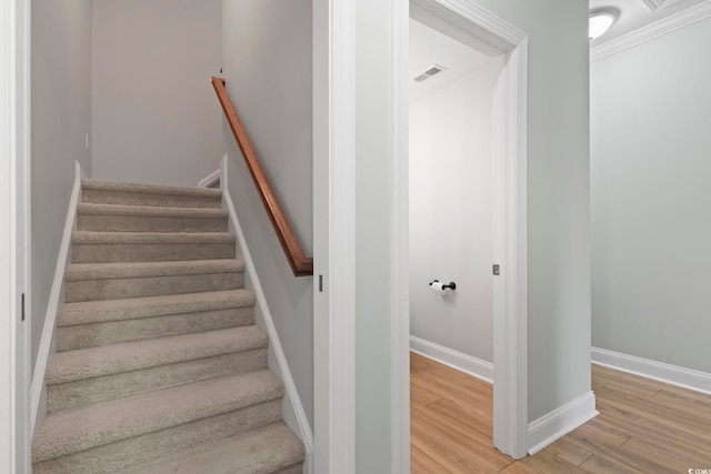 stairway with wood finished floors, visible vents, and baseboards