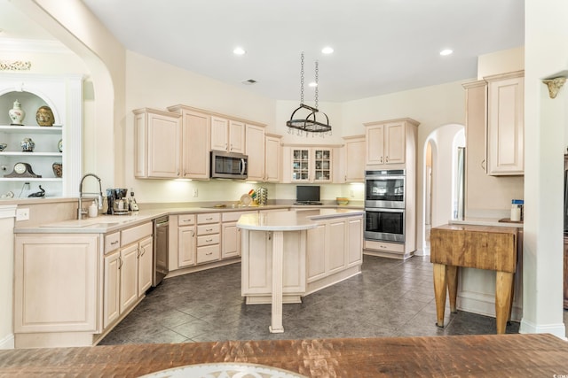 kitchen with stainless steel appliances, dark tile patterned floors, decorative light fixtures, and sink