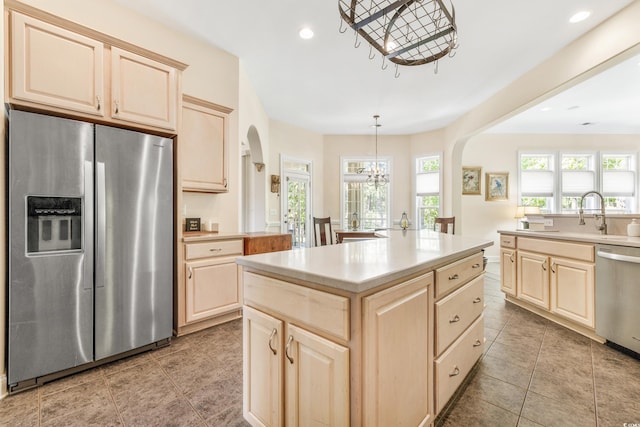 kitchen featuring hanging light fixtures, sink, a chandelier, appliances with stainless steel finishes, and a center island