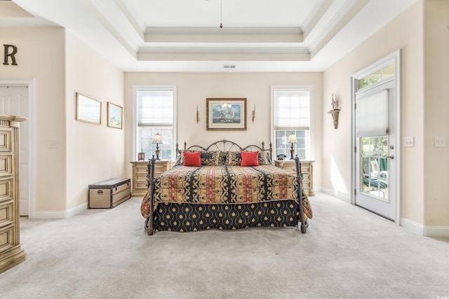 carpeted bedroom with multiple windows, crown molding, and a tray ceiling