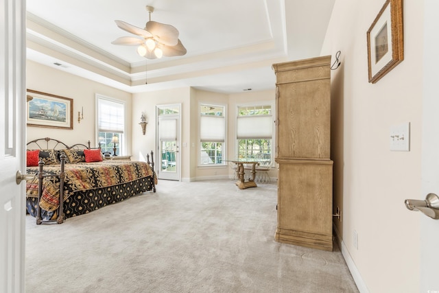 carpeted bedroom with access to outside, a tray ceiling, crown molding, and ceiling fan