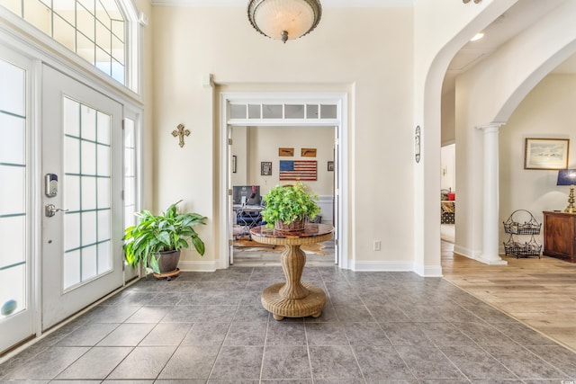 foyer entrance with decorative columns, a high ceiling, and hardwood / wood-style flooring