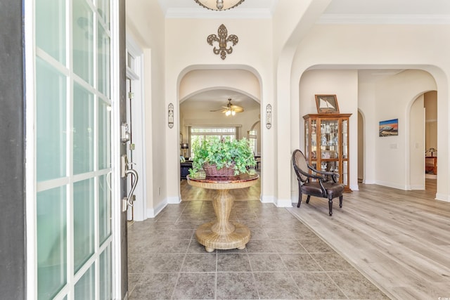 entrance foyer with ornamental molding, ceiling fan, and hardwood / wood-style floors