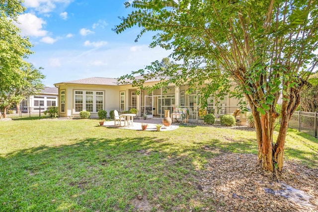 rear view of property with a lawn and a patio area