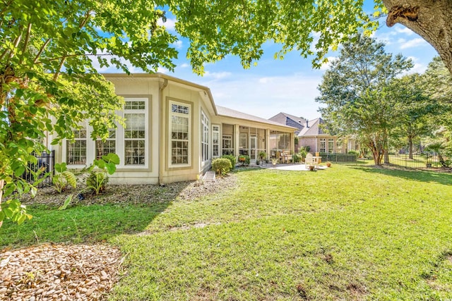 view of yard featuring a sunroom and a patio