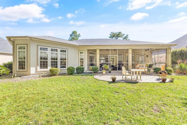 back of property with a yard, ceiling fan, and a patio