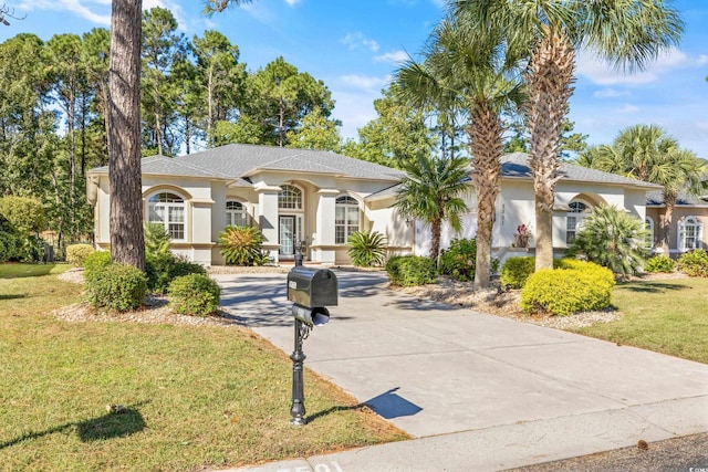 mediterranean / spanish home featuring a front lawn