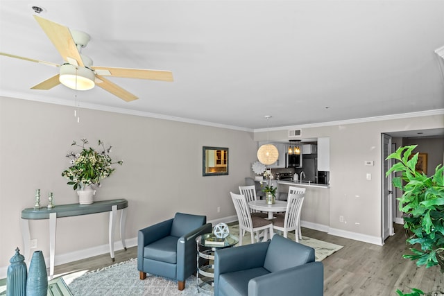 living room featuring ornamental molding, light wood-type flooring, and ceiling fan