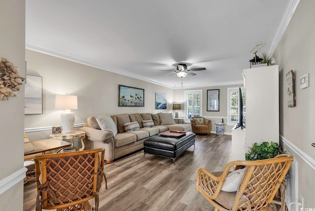 living room featuring ornamental molding, ceiling fan, and wood-type flooring