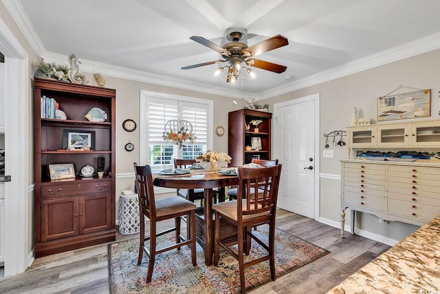 dining space featuring wood-type flooring, ornamental molding, and ceiling fan