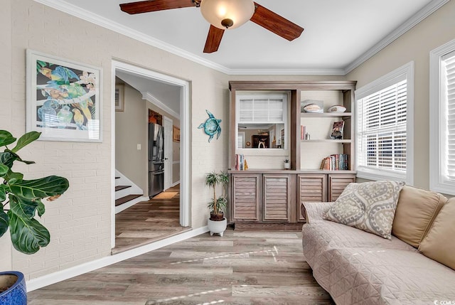 sitting room with ornamental molding, hardwood / wood-style floors, and ceiling fan