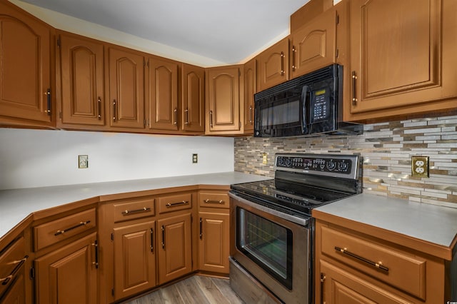 kitchen with decorative backsplash, light hardwood / wood-style flooring, and stainless steel range with electric stovetop