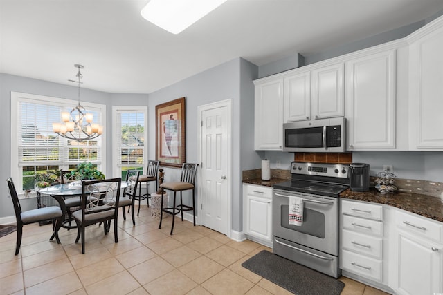 kitchen featuring white cabinets, stainless steel appliances, and light tile patterned floors