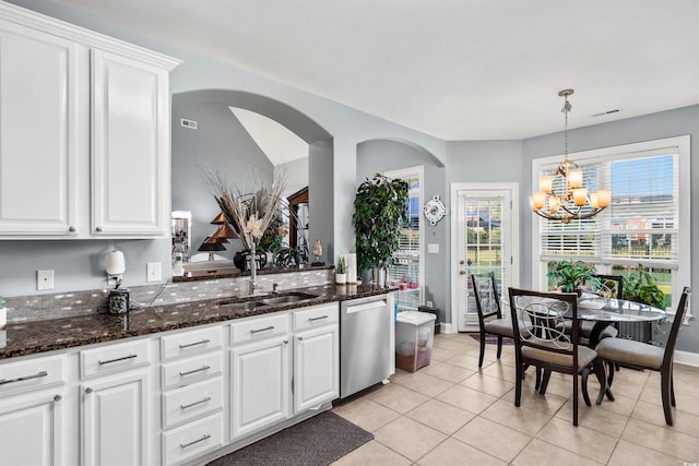 kitchen featuring light tile patterned floors, decorative light fixtures, stainless steel dishwasher, and white cabinetry