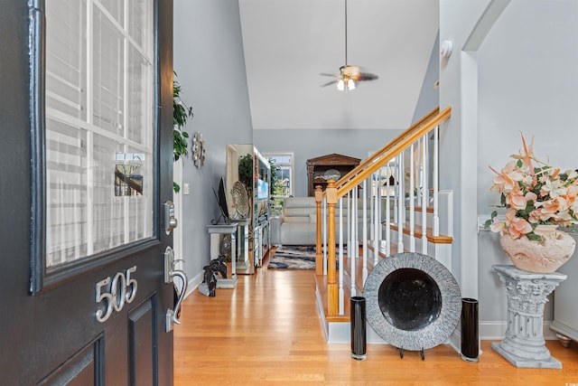 entryway with ceiling fan, light wood-type flooring, and high vaulted ceiling