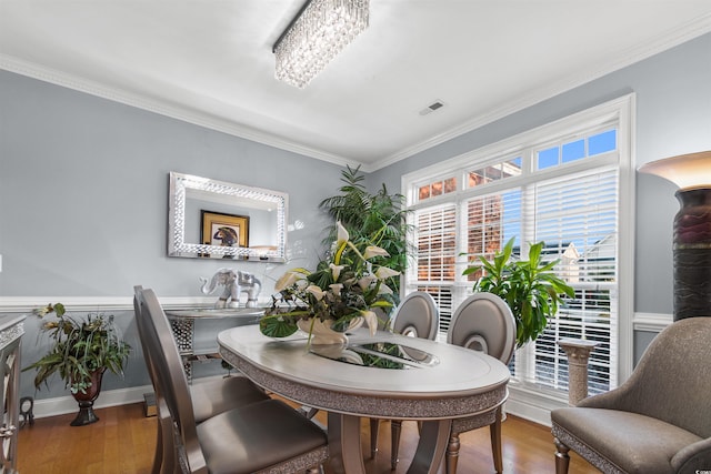 dining room with ornamental molding and hardwood / wood-style floors