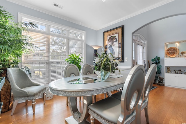 dining space featuring light hardwood / wood-style flooring and crown molding