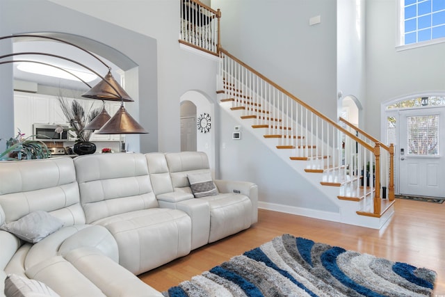 living room featuring a high ceiling and light hardwood / wood-style floors