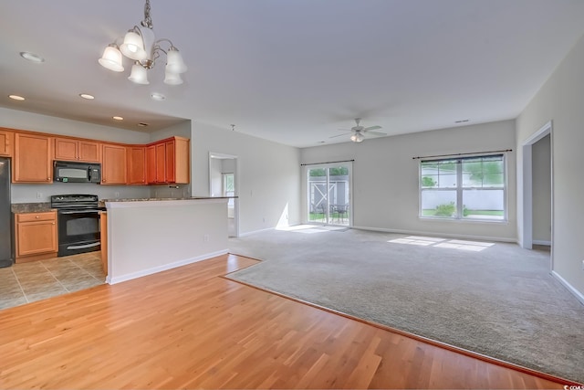 kitchen with ceiling fan with notable chandelier, black appliances, hanging light fixtures, and light hardwood / wood-style flooring