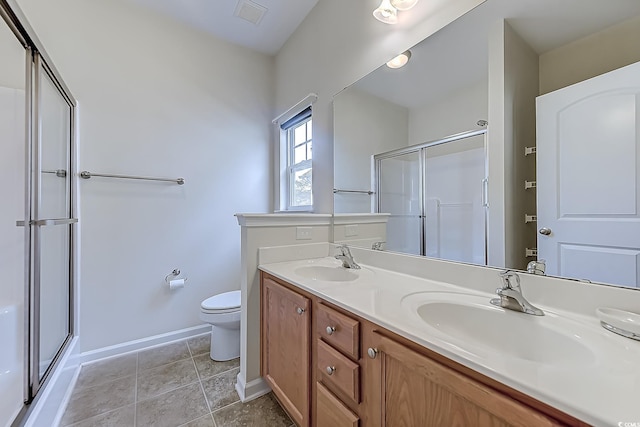 bathroom with an enclosed shower, vanity, tile patterned flooring, and toilet