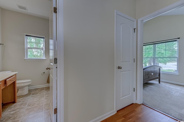 bathroom featuring wood-type flooring, vanity, and toilet