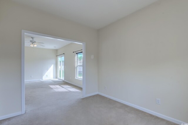 spare room featuring ceiling fan and light colored carpet