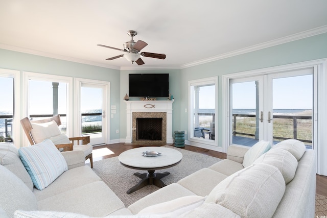 living room with ceiling fan, wood-type flooring, ornamental molding, and french doors