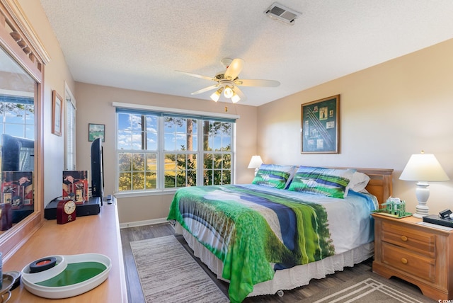 bedroom featuring hardwood / wood-style flooring, ceiling fan, and a textured ceiling