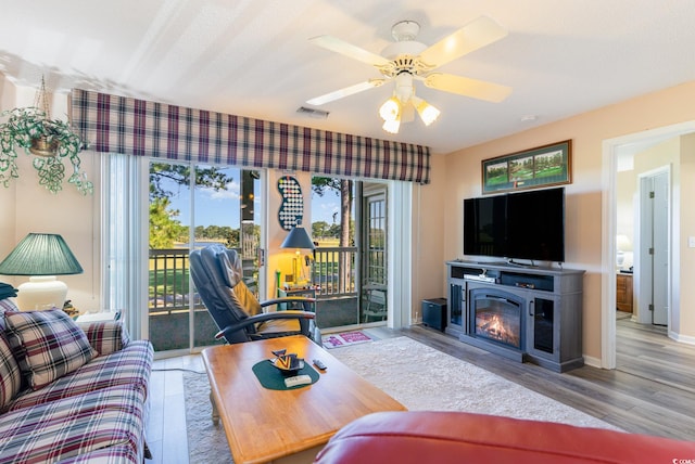 living room featuring light hardwood / wood-style floors and ceiling fan