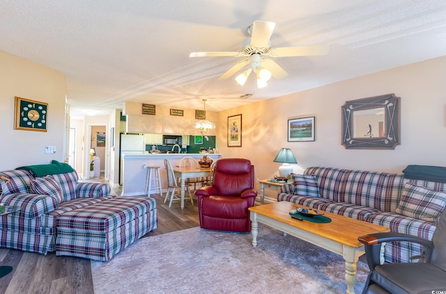 living room with ceiling fan, a textured ceiling, and hardwood / wood-style floors