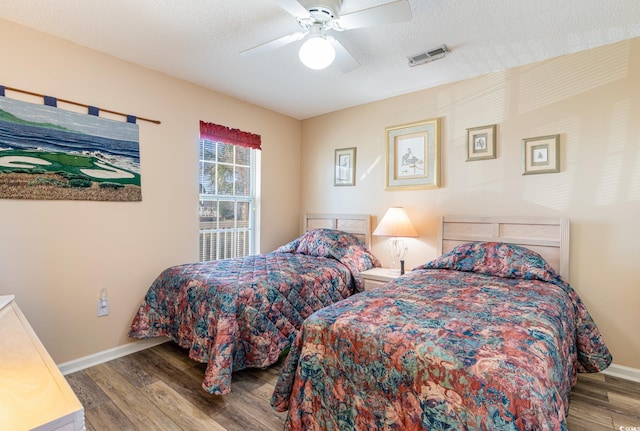 bedroom featuring ceiling fan, hardwood / wood-style flooring, and a textured ceiling