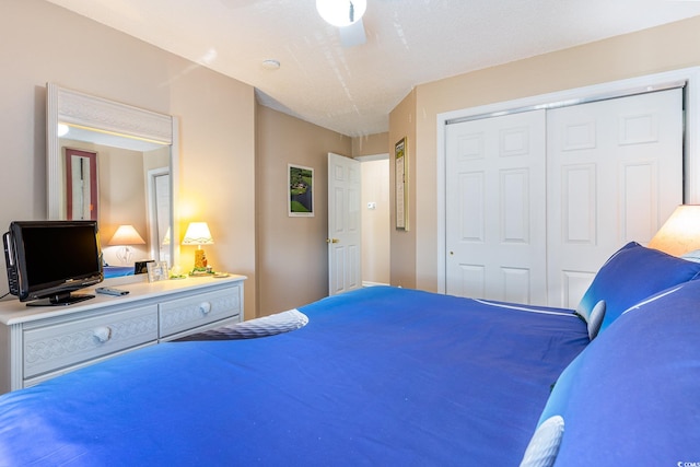 bedroom featuring a closet, a textured ceiling, and ceiling fan