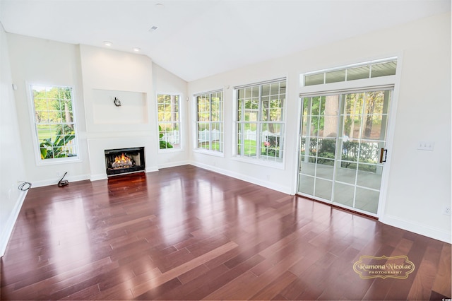 unfurnished living room featuring lofted ceiling and dark hardwood / wood-style floors